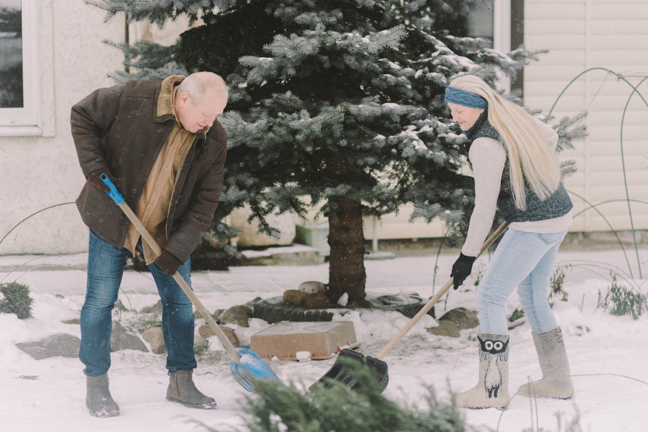 Services Elderly couple shoveling snow in winter, showcasing teamwork and outdoor activity.